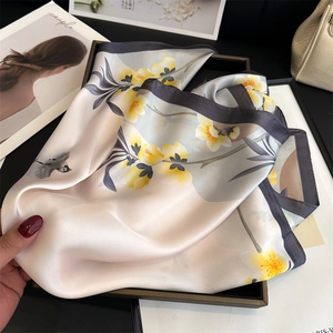 Dettaglio di elegante sciarpa in seta con fiori gialli e pittura a inchiostro di gazza