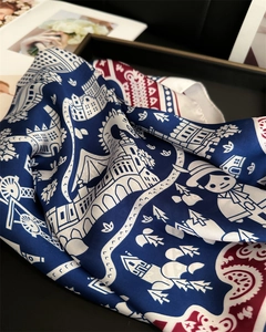 Detail of vintage silk scarf featuring blue castle prints and red paisley borders