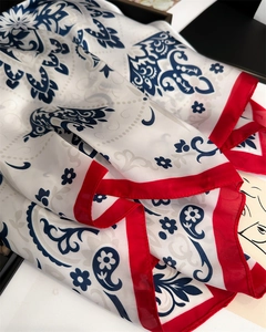 Detail of red and white paisley silk scarf showing smooth texture and vintage floral pattern