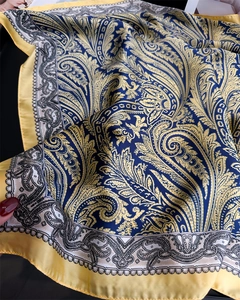 Dettaglio del foulard quadrato in raso con stampa paisley blu navy e giallo acceso