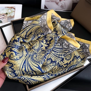 Dettaglio del foulard quadrato in seta con stampa paisley gialla e nera in display decorato