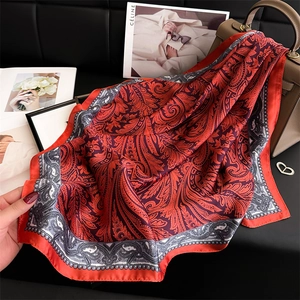 Sciarpa di seta arancione con motivi paisley vintage drappeggiata su una borsa