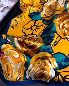 Macro detail of silk scarf with yellow rose print and deep blue hemmed edges