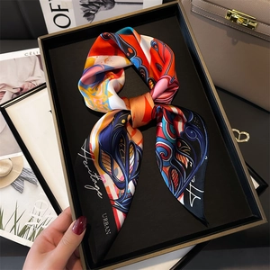 Colorful silk twilly scarf with abstract patterns tied on a premium handbag handle