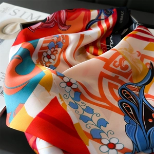 Close-up of vibrant silk square scarf with floral patterns and luxurious satin texture
