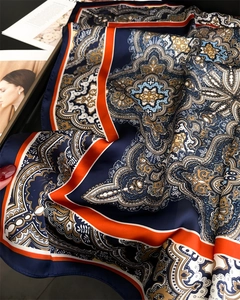 Detailed close-up showing the glossy satin texture and intricate paisley pattern of the silk scarf