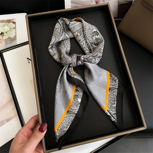 Detail of paisley silk scarf with orange borders in a premium black gift box packaging