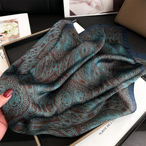 Detailed view of paisley silk-feel scarf draped elegantly in a luxury gift box