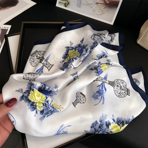 Close-up of silk scarf with blue porcelain pattern and elegant floral print
