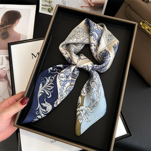Baroque style silk scarf with blue floral prints on a black display tray