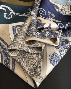 Detail of silk scarf with blue baroque floral pattern showing fabric luster and soft texture