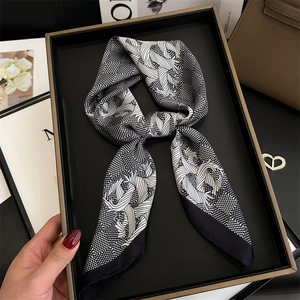 Elegant houndstooth silk scarf with floral patterns on a luxury gift display tray