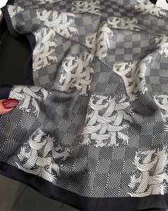 Detailed view of silk-like satin fabric with black and white houndstooth and wing patterns