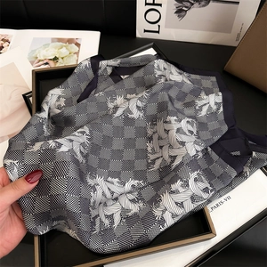 Detail of black and white silk scarf featuring checkerboard and vintage floral patterns