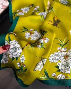 Detail of floral silk scarf showing smooth texture with peach blossoms and butterflies