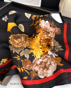 Close-up of silk square scarf featuring ginkgo leaves and butterfly patterns in a gift box