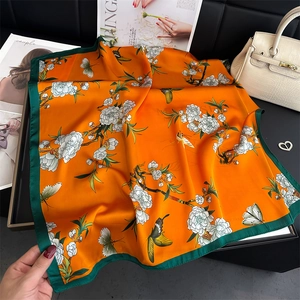 Elegant silk-like square scarf featuring vibrant orange floral and butterfly patterns