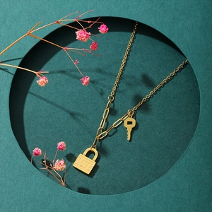 Nahaufnahme der goldenen Schlüssel-Schloss-Halskette mit LOVE-Gravur und Gliederketten-Design