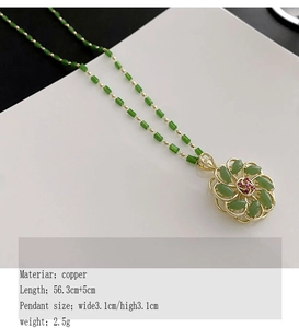 Detail of a rotating flower pendant with green gemstones and gold hollow petals