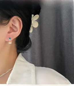 Close-up of model wearing rectangular multi-color zircon hoop earrings with silver finish