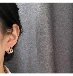 Side view of a model wearing C-shaped earrings with colorful zirconia stones