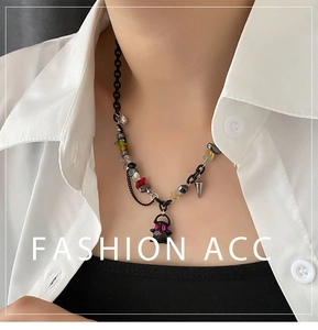 Detail of colorful stone beaded necklace with black ghost pendant and mixed chain link style