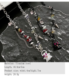 Titanium steel necklaces with ghost pendants and colorful gravel on a stone display