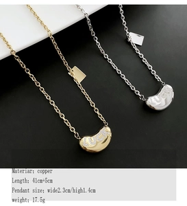 Close-up of golden and silver bean pendants with LUCKY lettering and crystal inlay