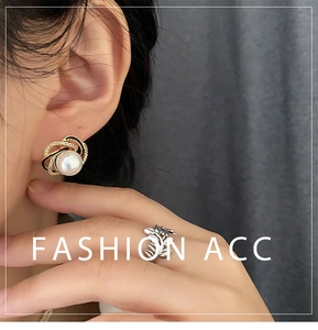Macro shot of French style gold pearl stud earrings with crystal pave details