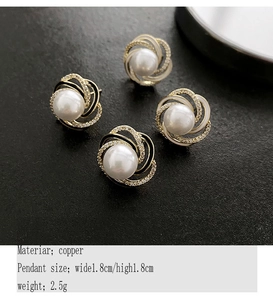 Macro detail of French flower pearl earrings with black and white enamel swirls