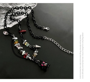 Close-up of black acrylic chain necklace with colorful stones and ghost pendant