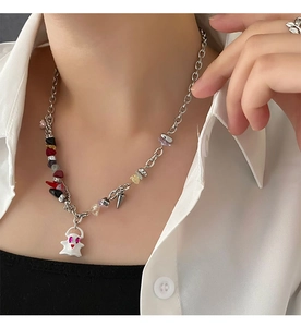 Ghost pendant necklace with gravel stone and heart eyes worn on model neckline
