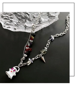 Detail of ghost pendant necklace with colorful crushed stones and asymmetric chain links