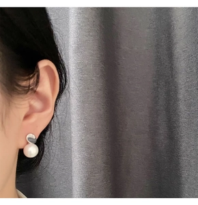 Detail of elegant 925 silver faux pearl earring worn on model against grey backdrop
