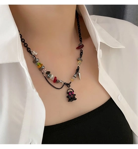 Detail of beaded necklace with colorful gravel stones and black ghost pendant on a model