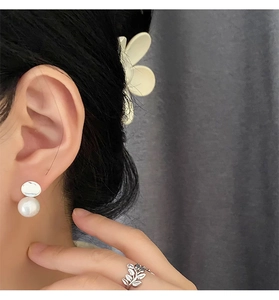 Detail of elegant 925 silver leaf ring and pearl drop earrings on a female model