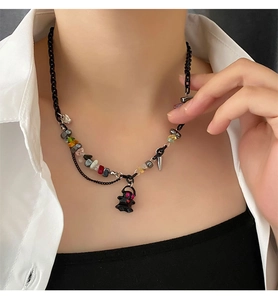 Detail of punk ghost pendant necklace featuring colorful crushed stones on black chain