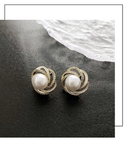 Detailed macro view of French style pearl flower earrings with white enamel on black stone