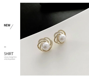 Detail of elegant pearl stud earrings with spiral gold petals and sparkling rhinestones