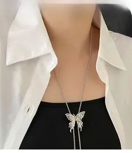 Dettaglio della collana a farfalla argento stile bolo tie su camicia bianca