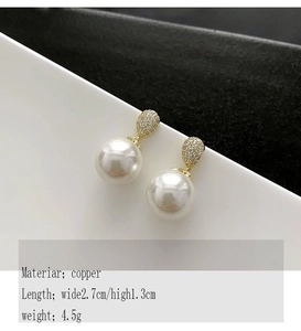 Detailed view of pearl earrings with copper teardrop studs and diamond-like accents