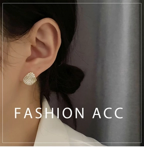 Close-up of minimalist gold irregular earrings with pavé crystals on a model