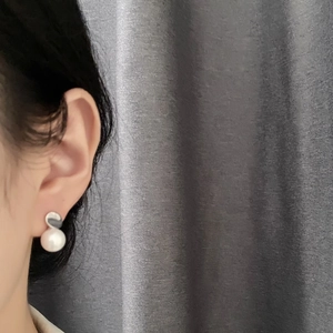Elegant 925 silver pearl stud earrings on model with a white round pearl and metal base