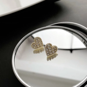 Elegant heart-shaped stud earrings with pearl border and sparkling crystals on mirror