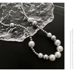 Macro detail of mixed silver metal beads and gradient pearls on a minimalist necklace