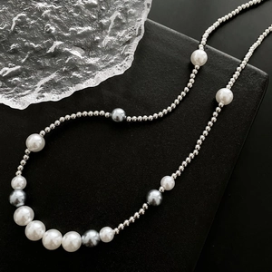 Chic unisex pearl necklace featuring silver beads and grey pearls on a black display