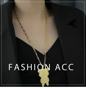 Detailed close-up of a golden bear pendant with super star engraving on a sweater chain