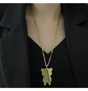 Detail of a golden bear necklace featuring super star engraving on a square link chain