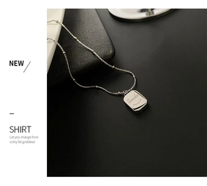 Detailed macro view of silver smile necklace pendant on elegant black leather surface
