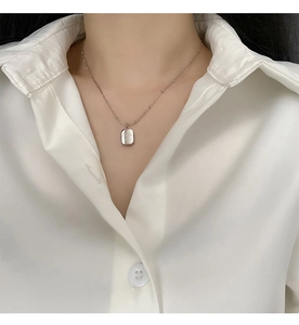 Detailed close-up of a silver beaded chain necklace with an engraved smile pendant